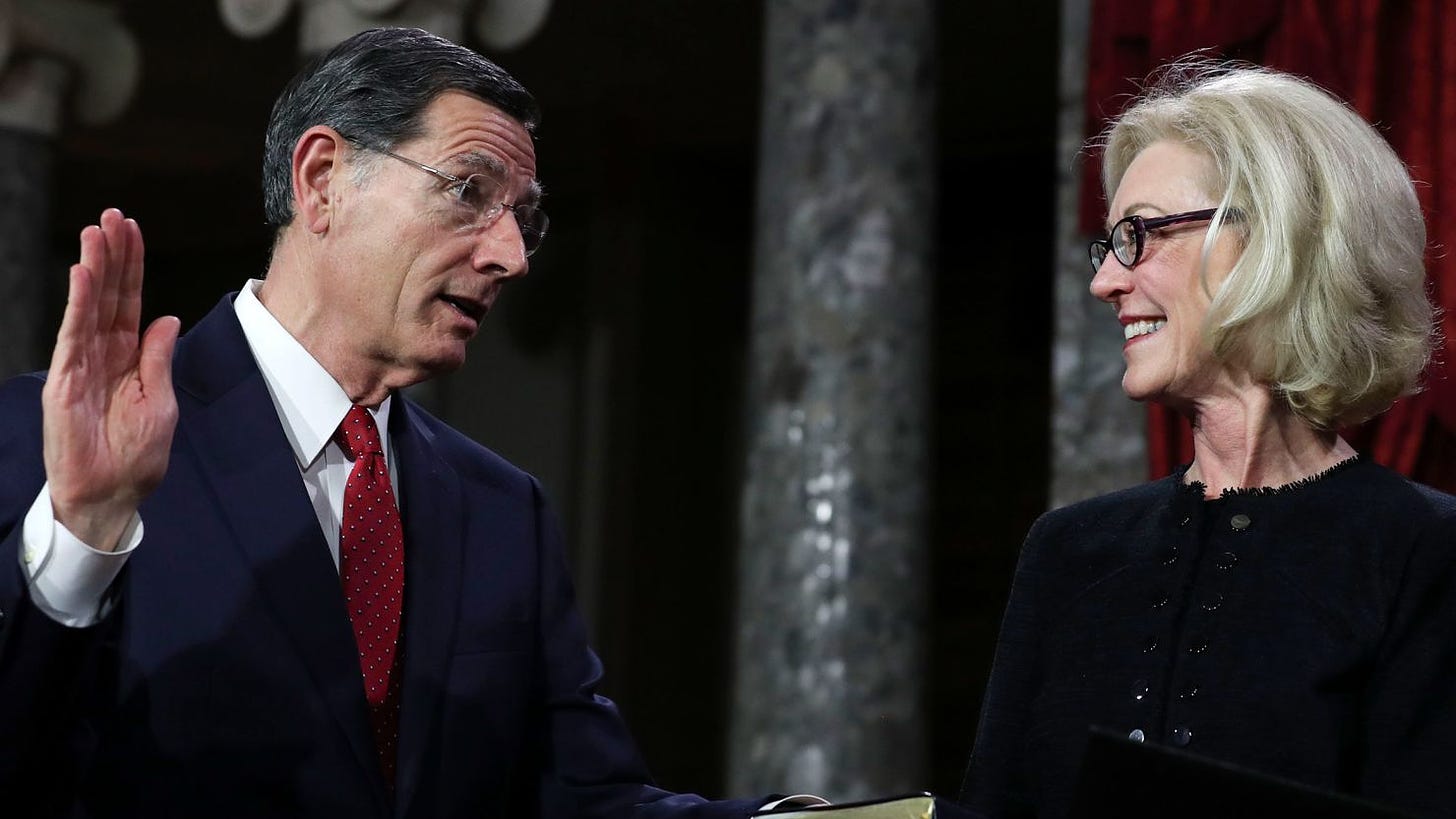 Bobbi Barrasso, right, wife of Sen. John Barrasso, left, smiles as her husband during the swearing-in re-enactments for recently elected senators in the Old Senate Chamber on Capitol Hill in Washington, DC, in January 2019.