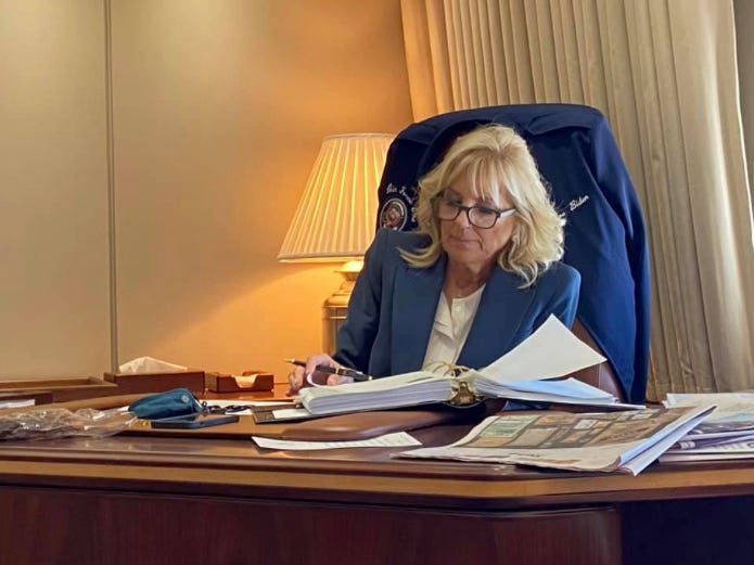Jill Biden sitting at the President's desk on Air Force One at a table of classified documents. Jill Biden sitting at the President's desk on Air Force One at a table of classified documents.