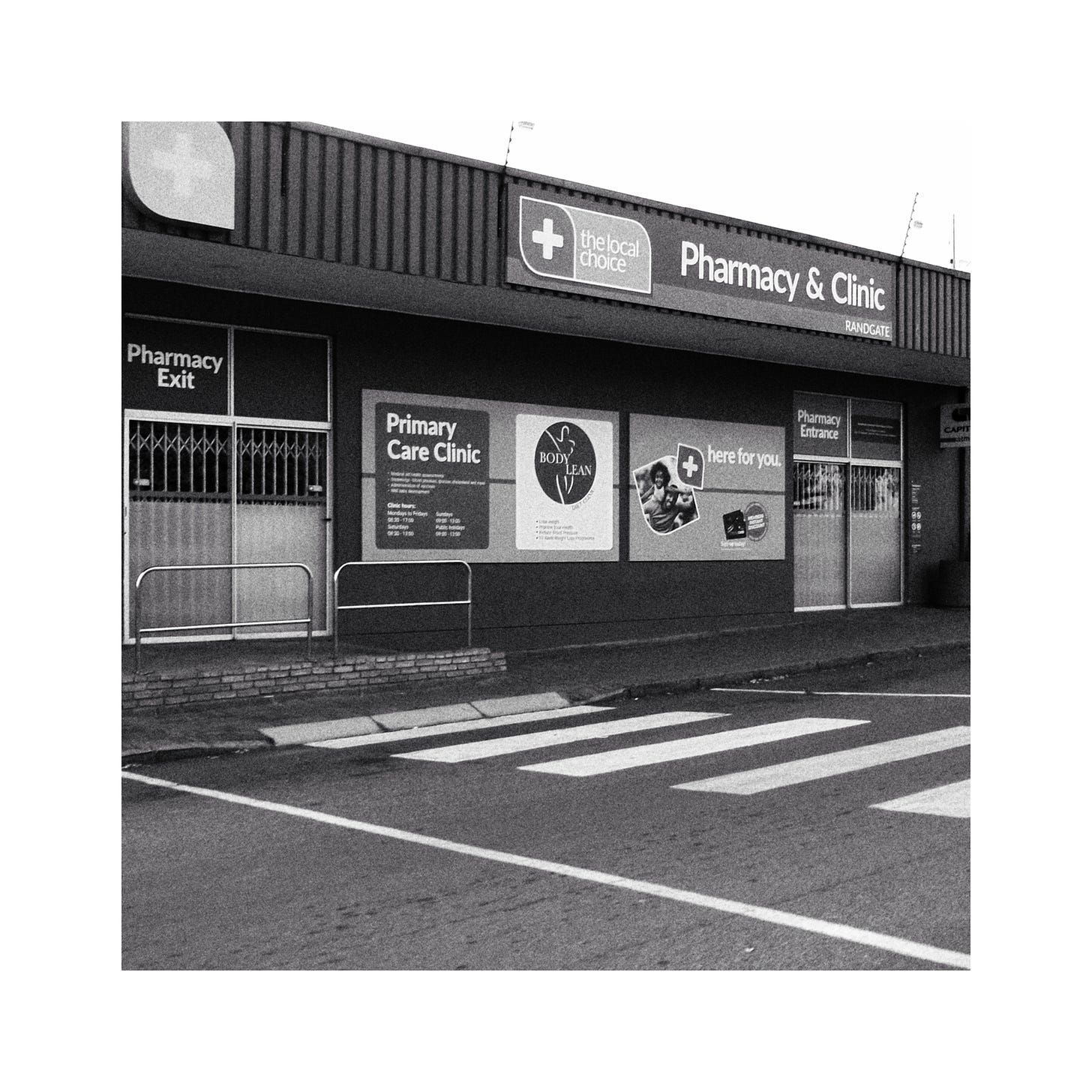 An image of a local pharmacy and clinic. Image in black and white.