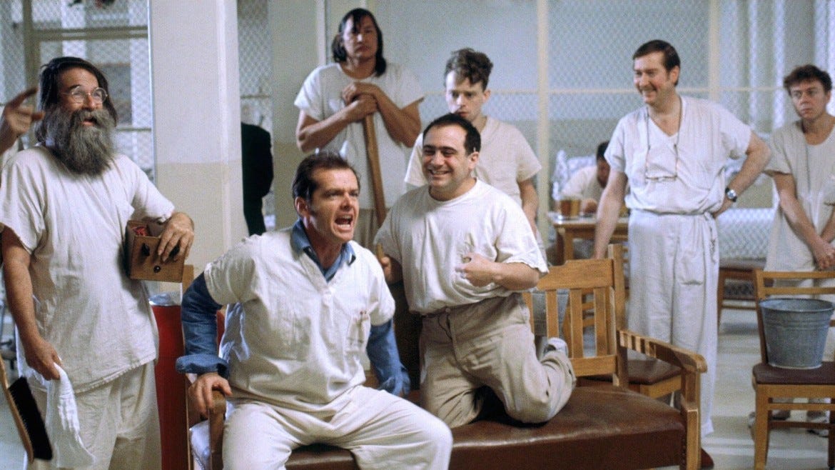 Scene from One Flew Over the Cuckoo’s Nest. Jack Nicholson holds court in a secure ward, surrounded by the other patients who look on, smiling