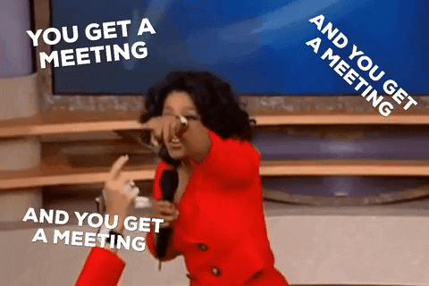 Oprah Winfrey handing out meetings to an audience.