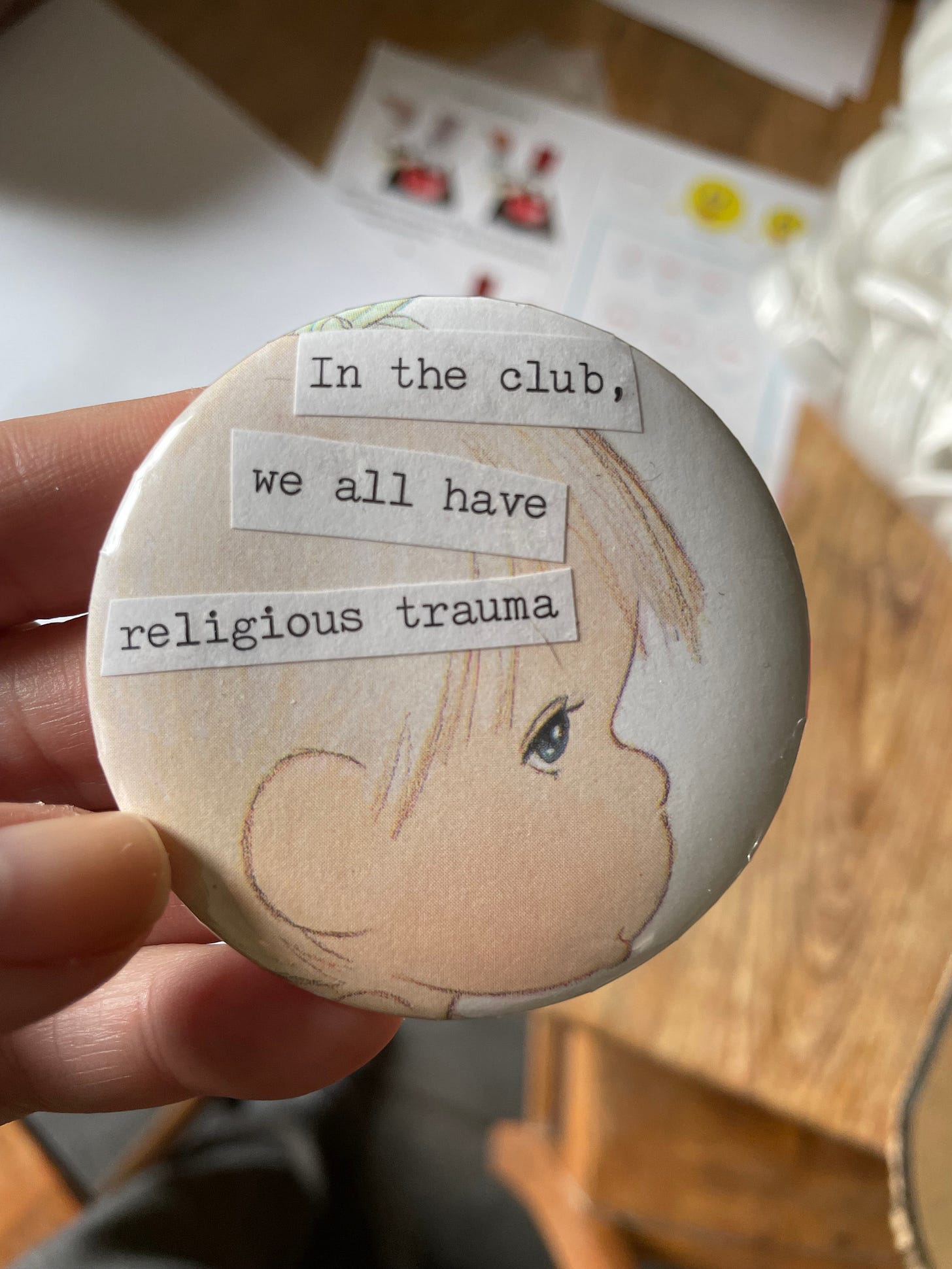 a button with a precious moments head that says in the club we all have religious trauma