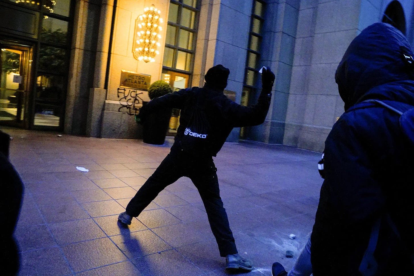 A protester throws a rock at a window during Saturday's demonstrations in Atlanta.