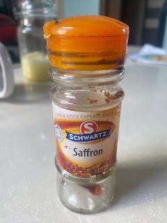 A jar of saffron. It's small, like the rows of spice jars i the supermarket. It's also stained with brown marks and the label is faded.