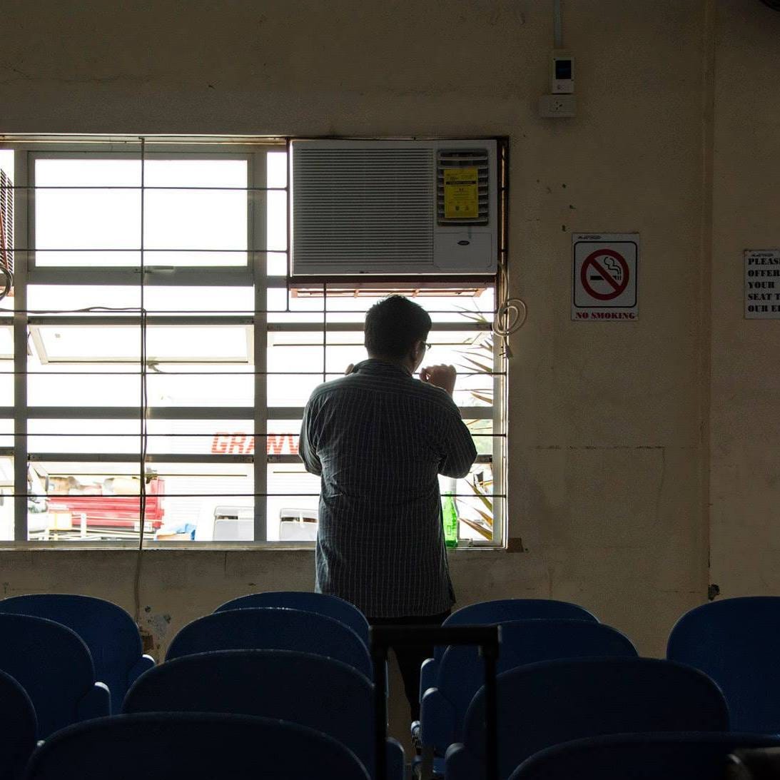 Scene of a man looking against a window.