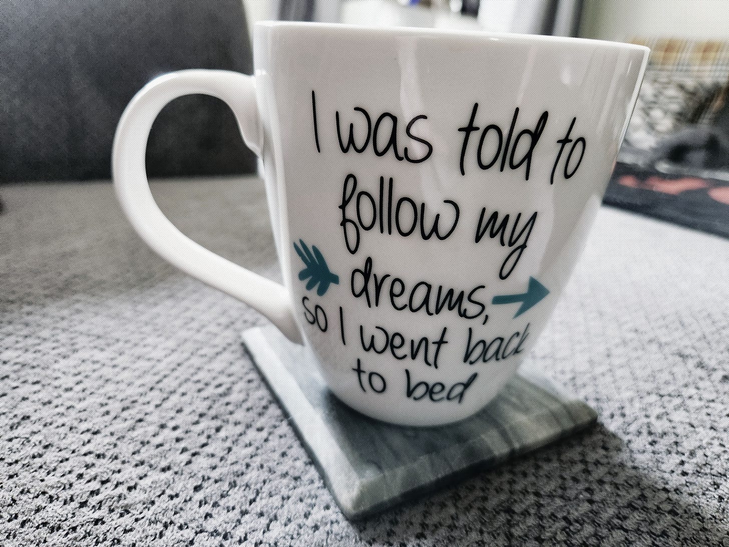 Coffee mug saying "I was told to follow my dreams, so I went back to bed"