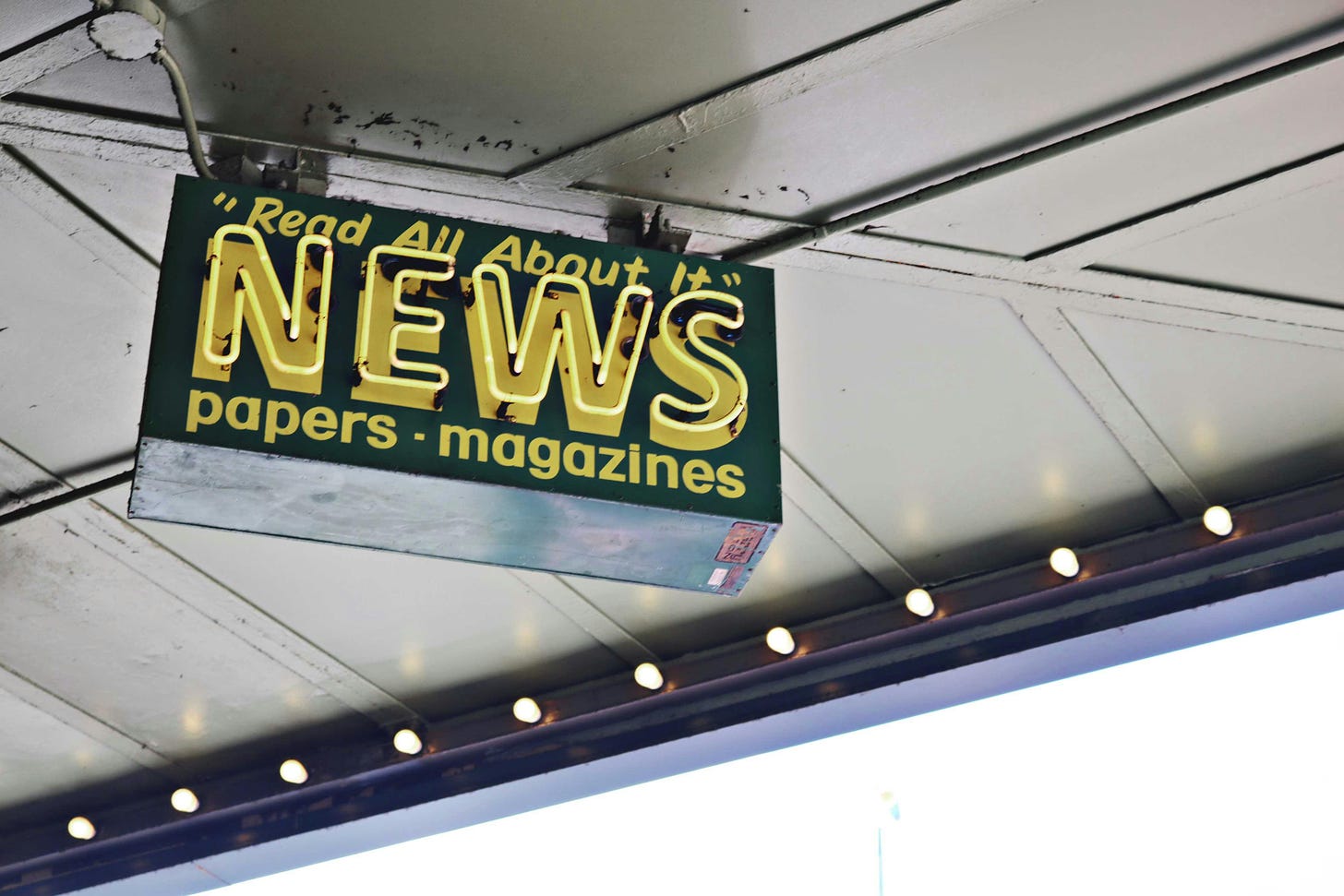 A vintage sign reads "Read All About It!" News, papers, magazines