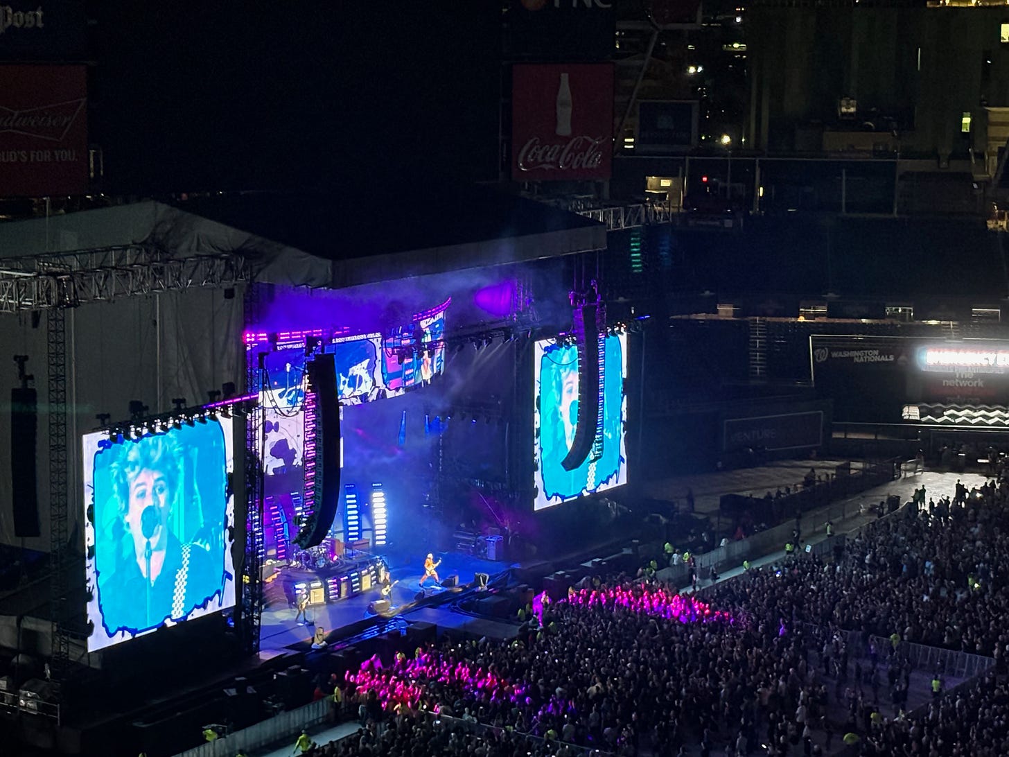 Concert in a stadium with giant screens with Green Day singer Billy Joe on them