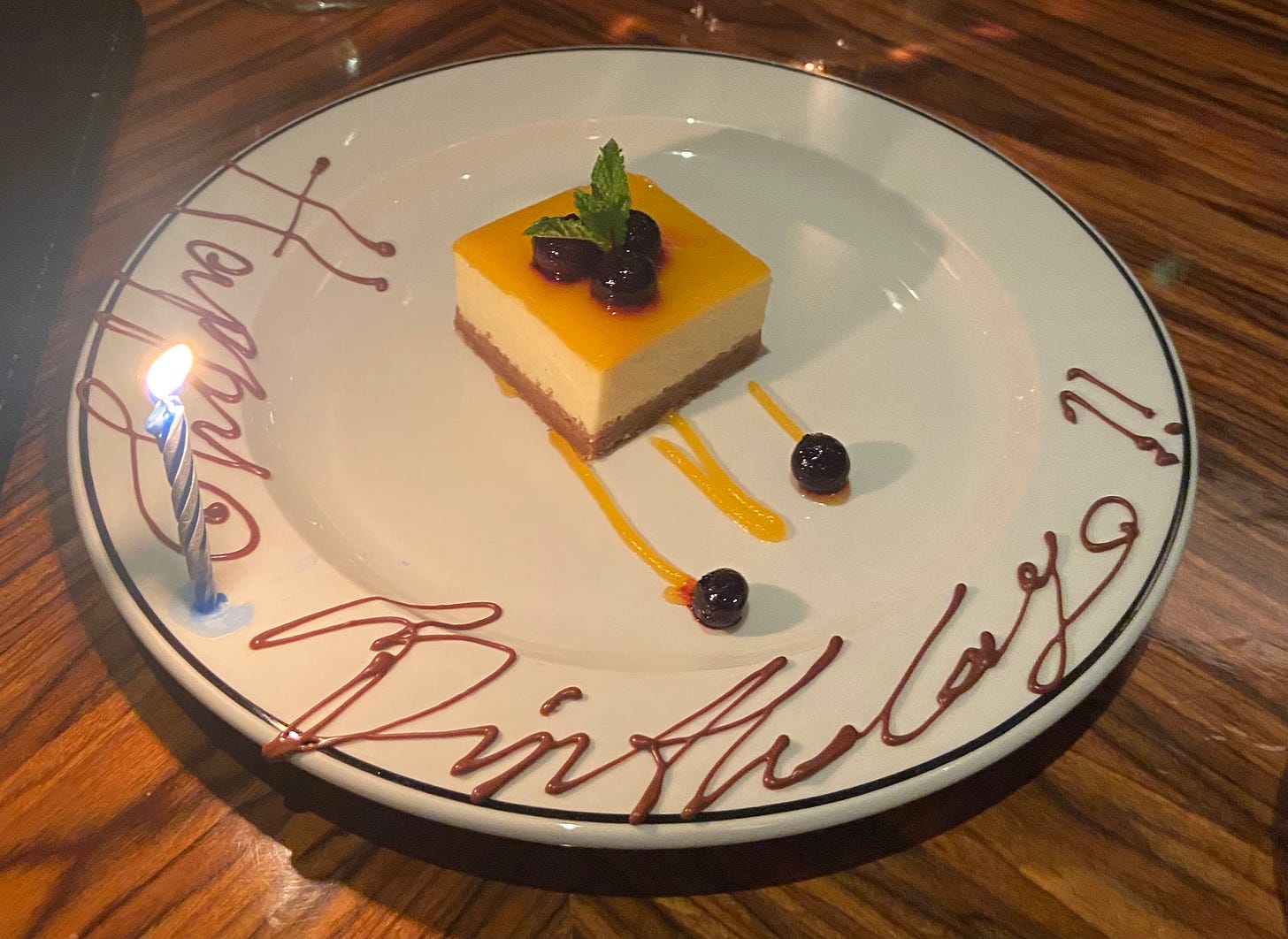 Cheesecake with Happy Birthday written on the plate in chocolate.