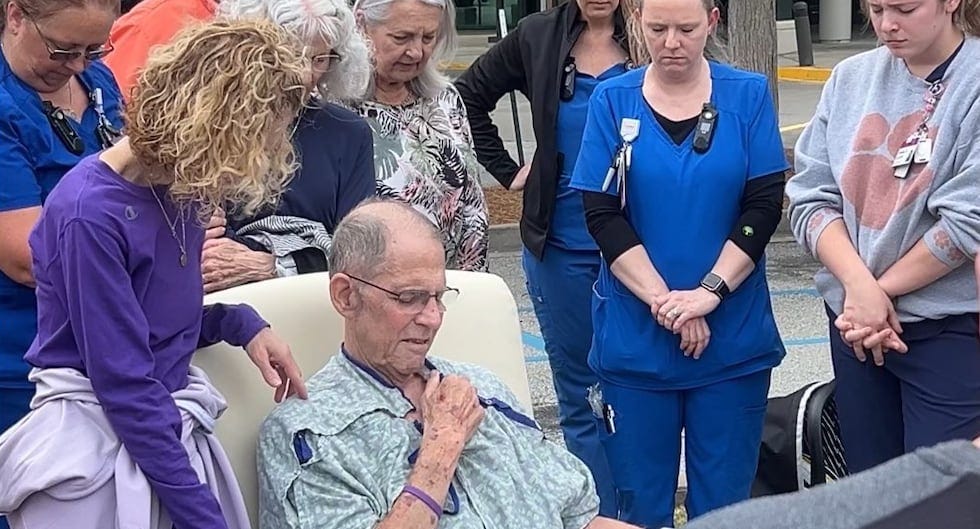 Friends and family form a prayer circle around Robin Morse, former police chief of Laurens and...