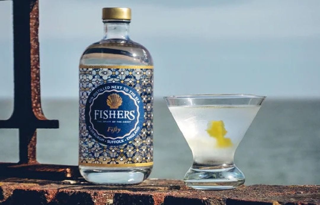 A bottle of Fishers Gin and a cocktail by the sea