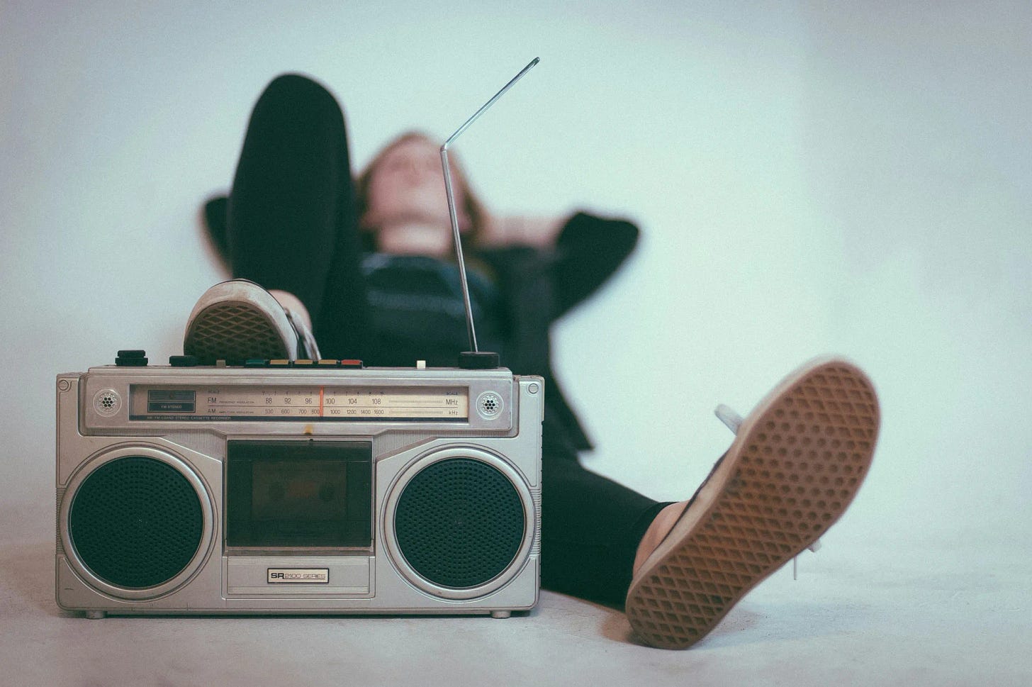 Person lying down with an old style tape player Person lying down with an old style tape player