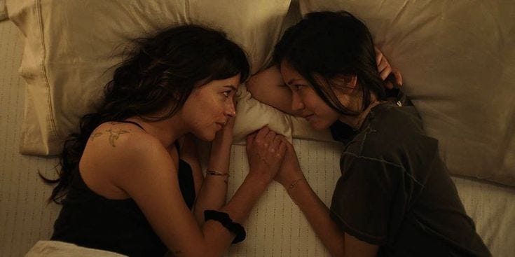 Jane e Lucy deitadas na cama de frente uma para a outra