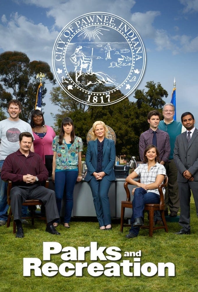 The cast of Parks and Rec under the seal of the City of Pawnee