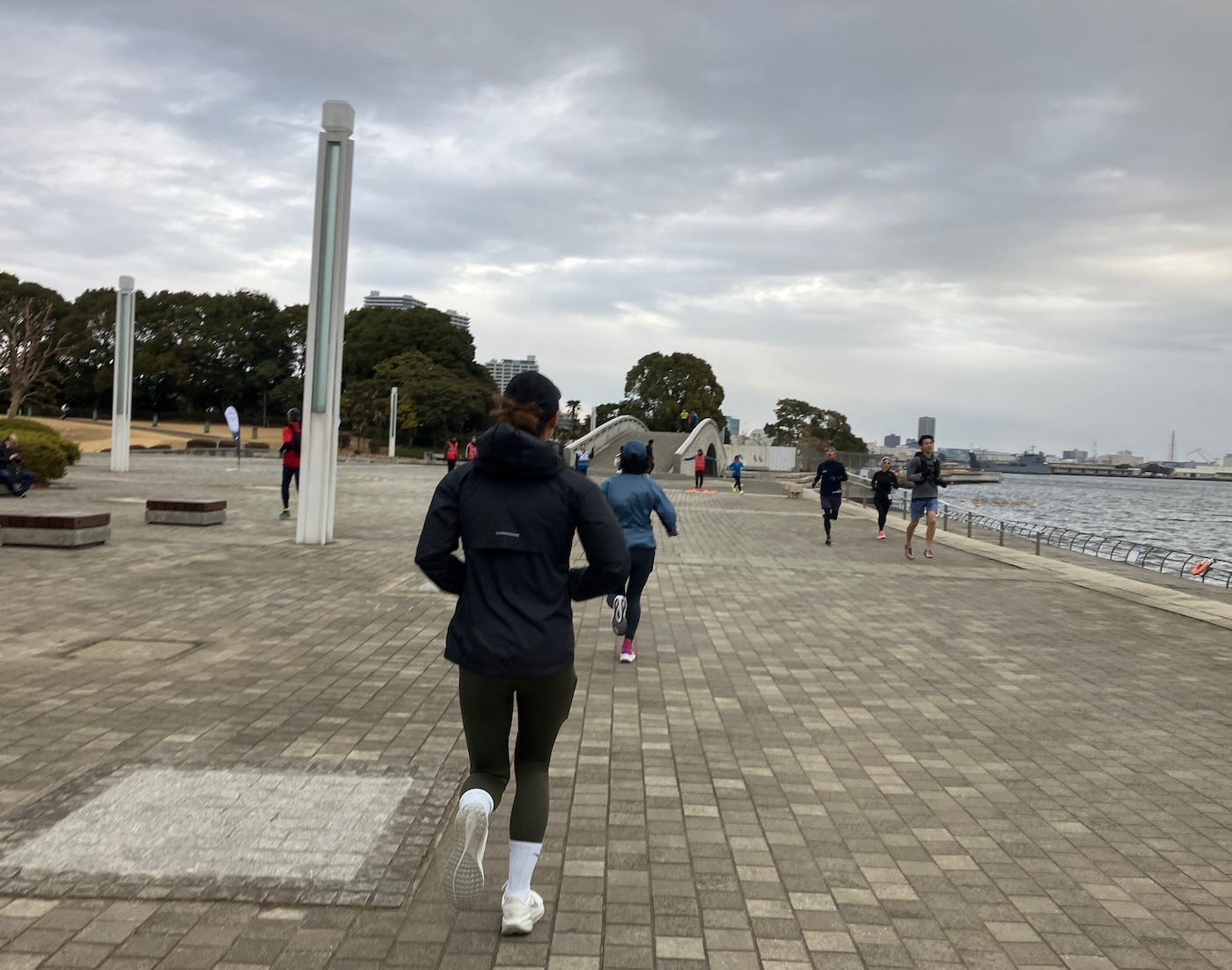 Runners in both directions on the wide concrete of the park