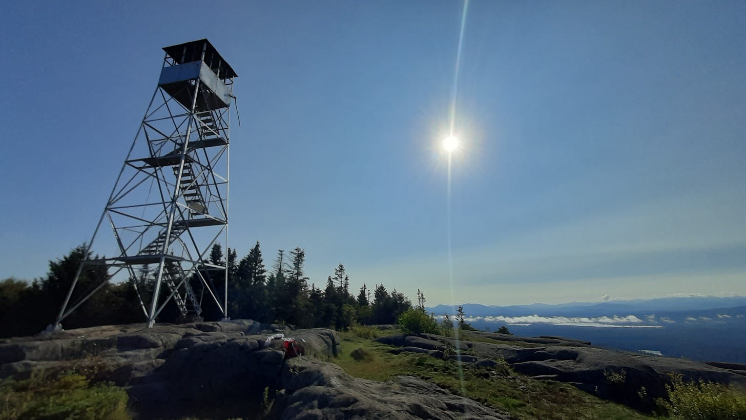 The St. Regis Mountain fire tower is seen with clear blue skies and the sun shining brightly