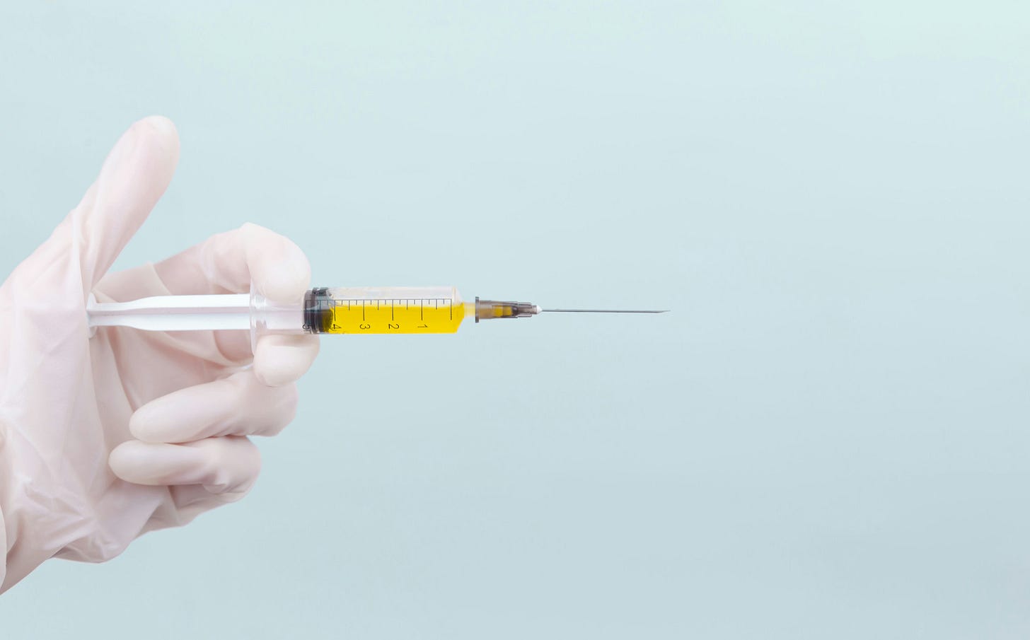 gloved hand holding syringe representing how weight loss drugs are administered