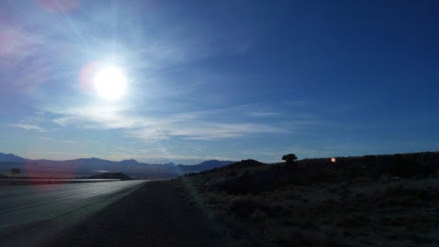 Sunrays shining over a mountainous landscape.