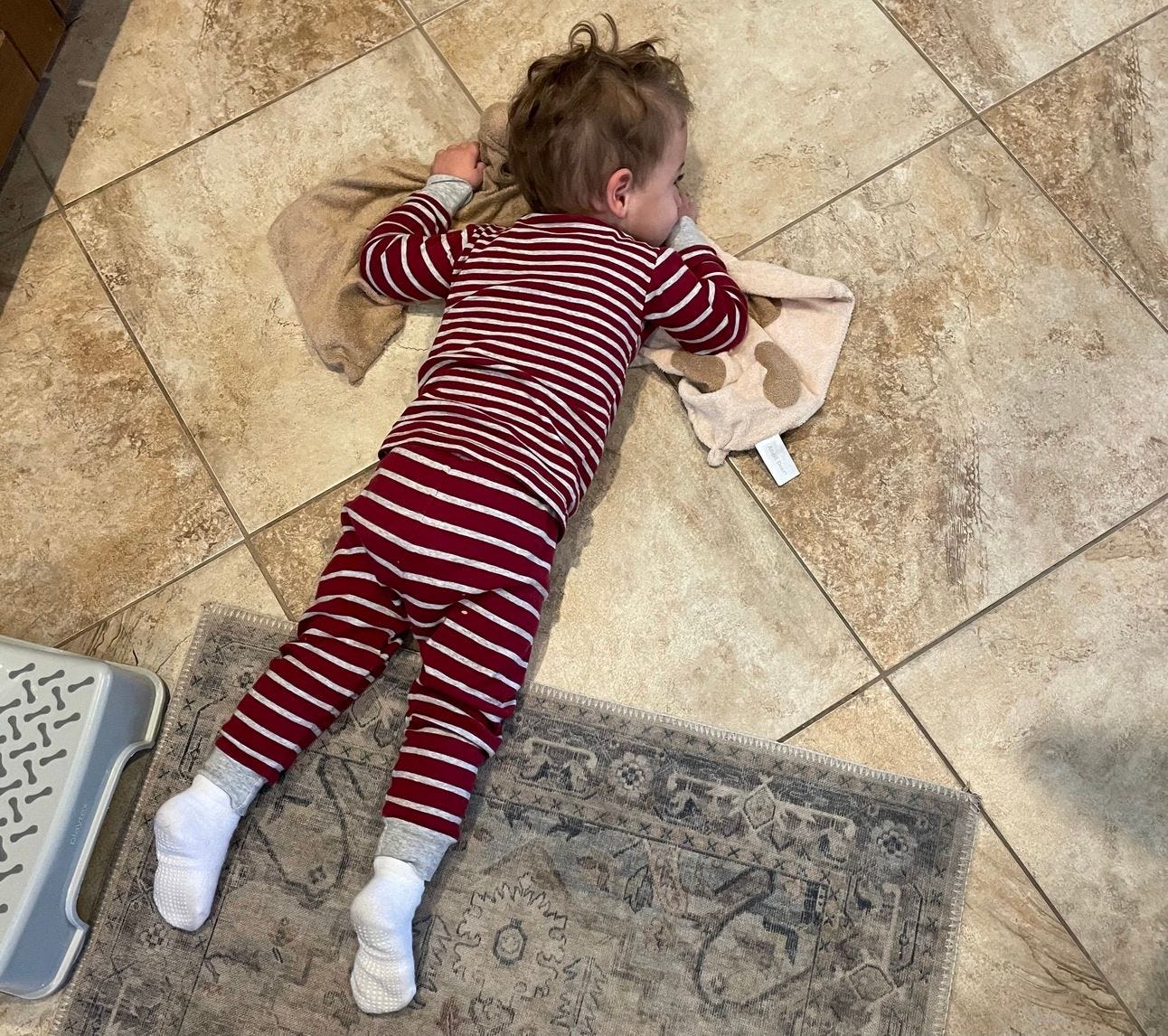 a boy laying on the ground holding his loves. a boy laying on the ground holding his loves.