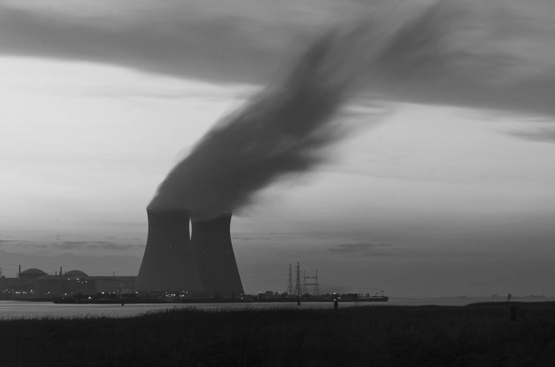 skyline photography of nuclear plant cooling tower blowing smokes under white and orange sky at daytime skyline photography of nuclear plant cooling tower blowing smokes under white and orange sky at daytime