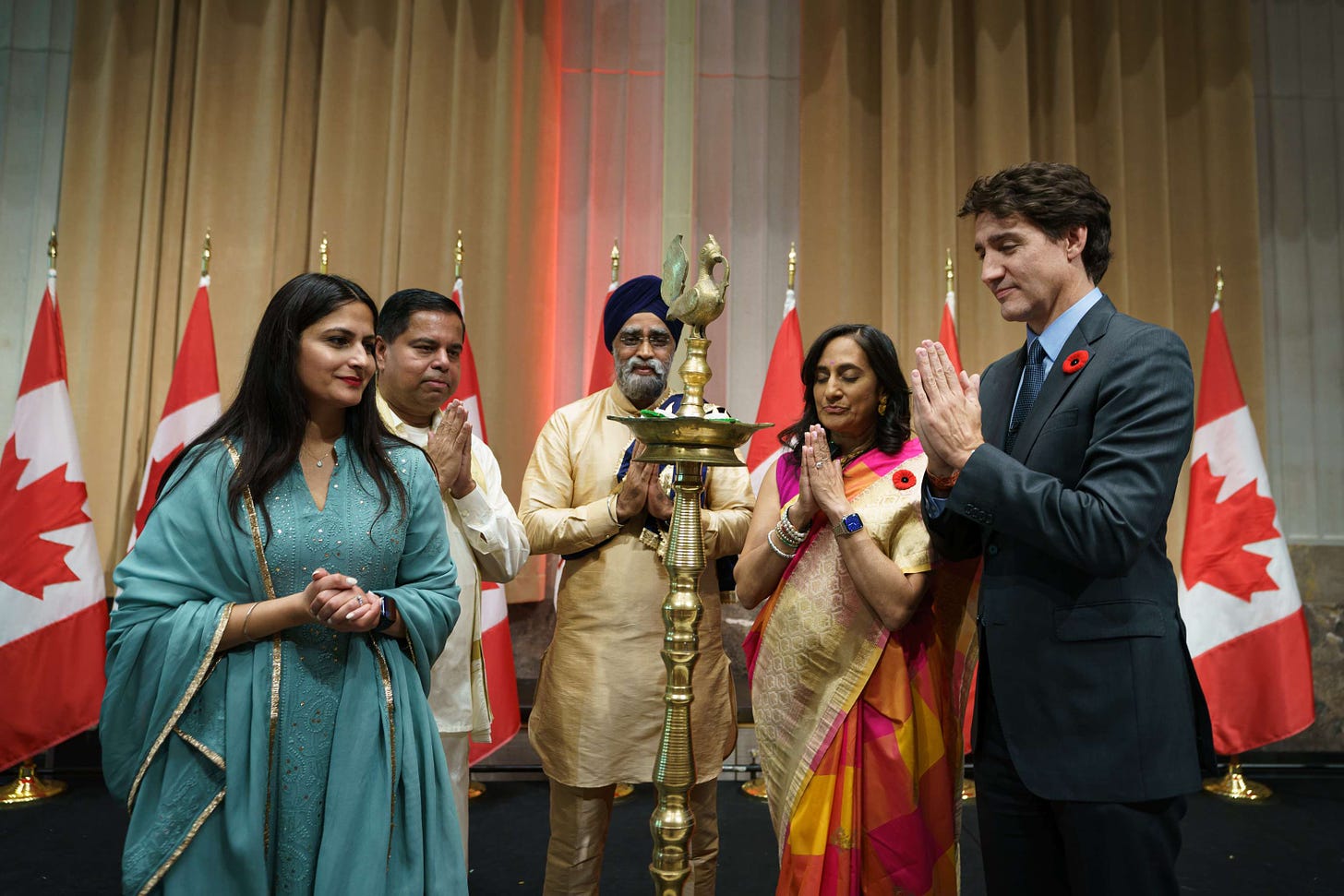 Prime Minister Justin Trudeau, members of Cabinet, and members of the Hindu community are in front of a diya at a Diwali celebration in Ottawa.