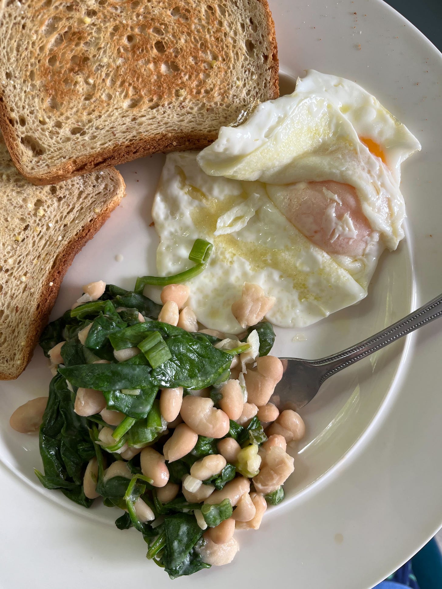 white beans with spinach, an over easy egg, and toast