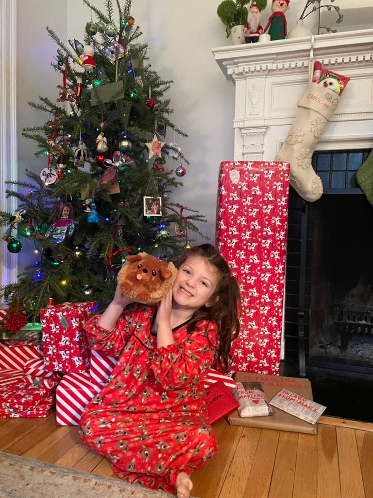 Child on Christmas Morning with gifts and a hot dog stuffie