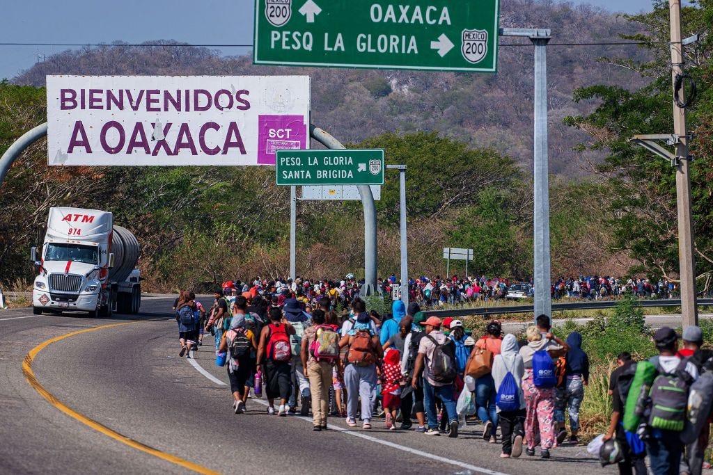 Migrants walking on a road during a caravan heading to the United States border in Arriaga, Mexico.