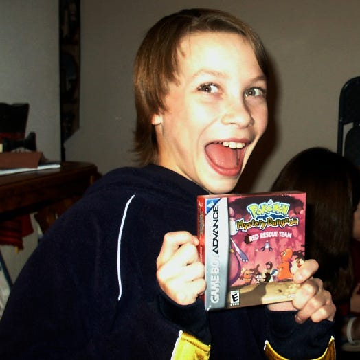 A photograph of Slix when he was younger, holding his copy of Pokémon Mystery Dungeon: Red Rescue Team