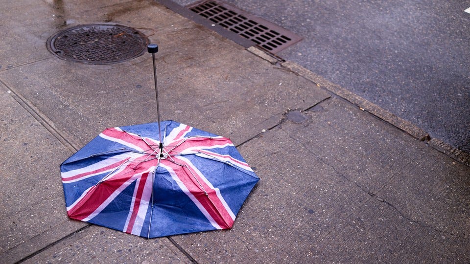 British flag umbrella turned inside out on a wet sidewalk