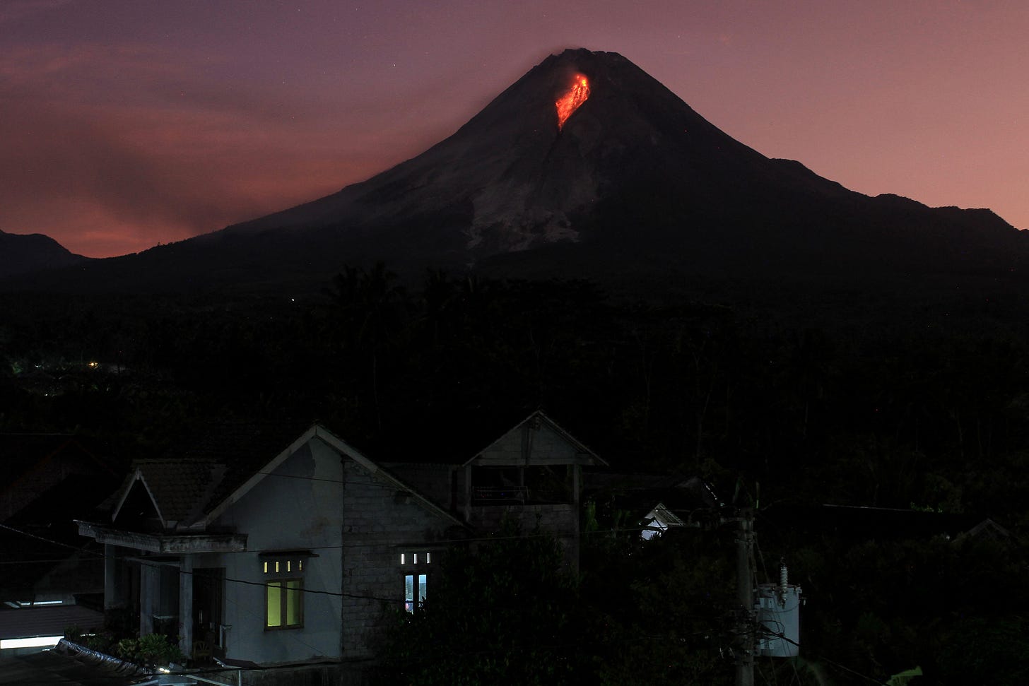 Lava spews out of Mount Merapi, Indonesia's most active volcano, as seen from the Kaliurang Selatan village in Srumbung, Magelang, Central Java on March 12, 2023. (Photo by Devi Rahman/AFP via Getty Images)
