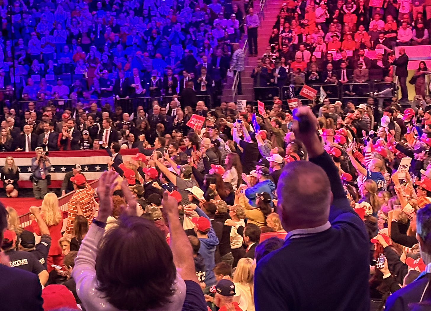 People in the stands at Madison Square Garden's Trump rally cheer the speakers.