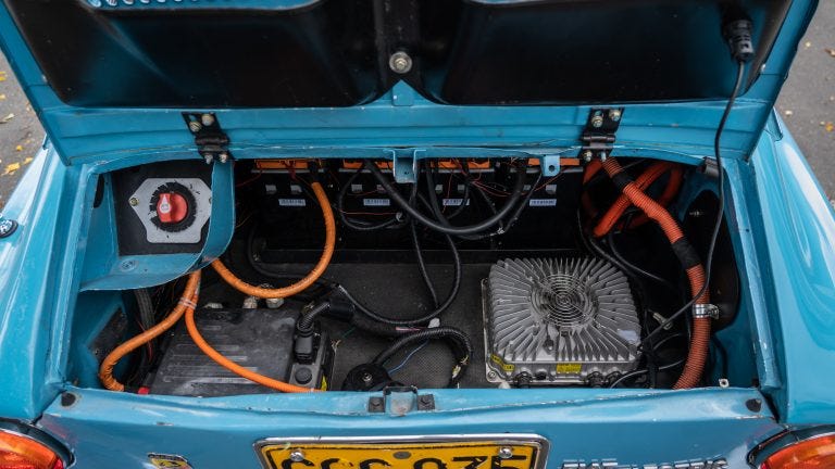 A photo of an opened car boot with electric battery components inside.