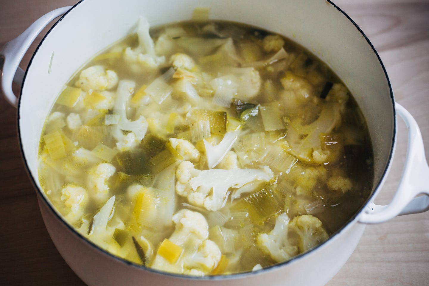 A soup pot with cook cauliflower and leeks in broth. 