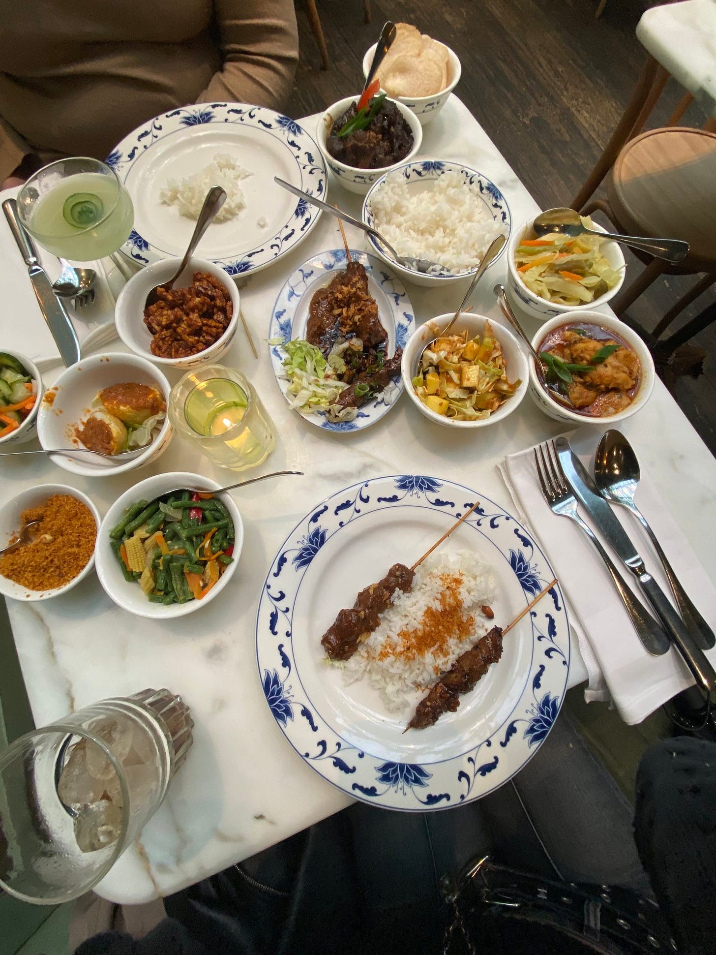 Photograph of a table of small dishes of food with a medium bowl of rice.