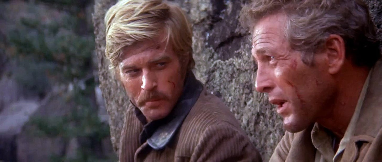 From Butch Cassidy and the Sundance Kid: Butch and Sundance stand on a cliff over a river, deciding whether or not to jump. Sundance glares at Butch.