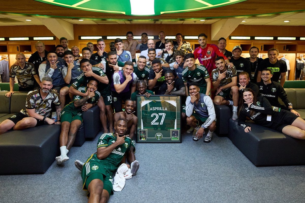 Team poses in the locker room after the win