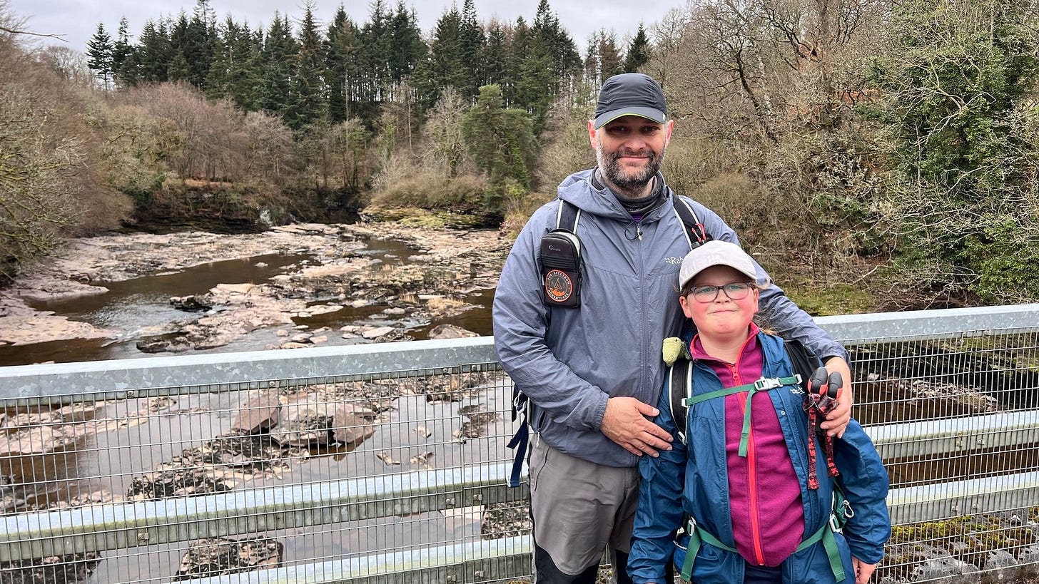 Ian and Eve standing on the bridge at the end of the Clyde Walkway with the Falls of Clyde behind us