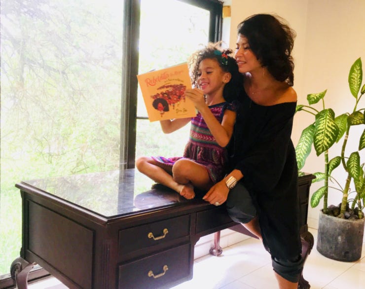 Dr. Oriel Maria Siu and her daughter Suletu reading “Rebeldita” (LA Times)