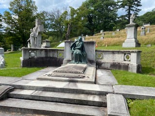 a picture of a real gravestone and statue in a cemetery
