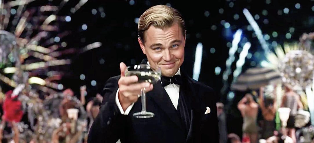 Leonardo DiCaprio in The Great Gatsby holding up his drink.