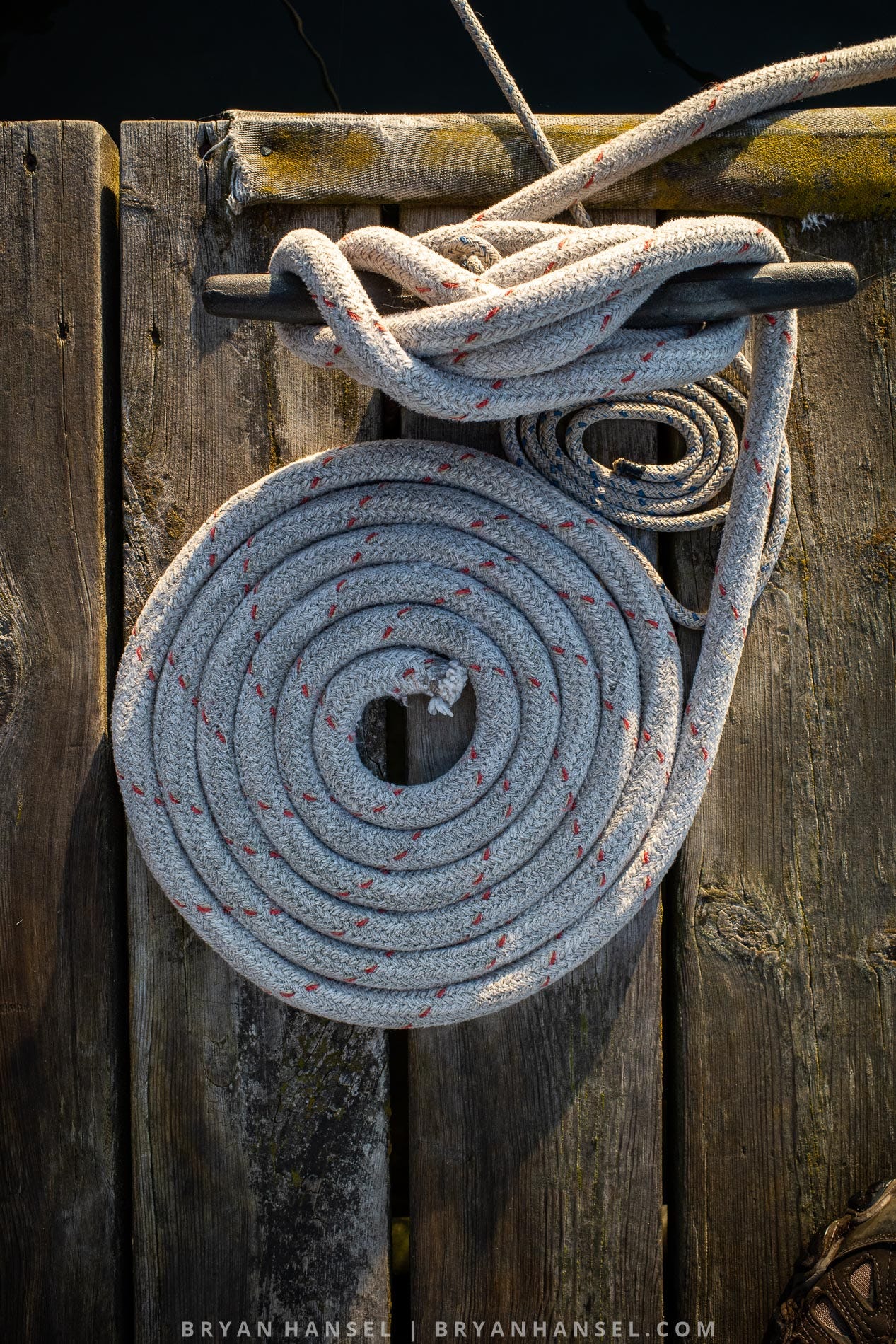 a rope coiled up on an old wood dock