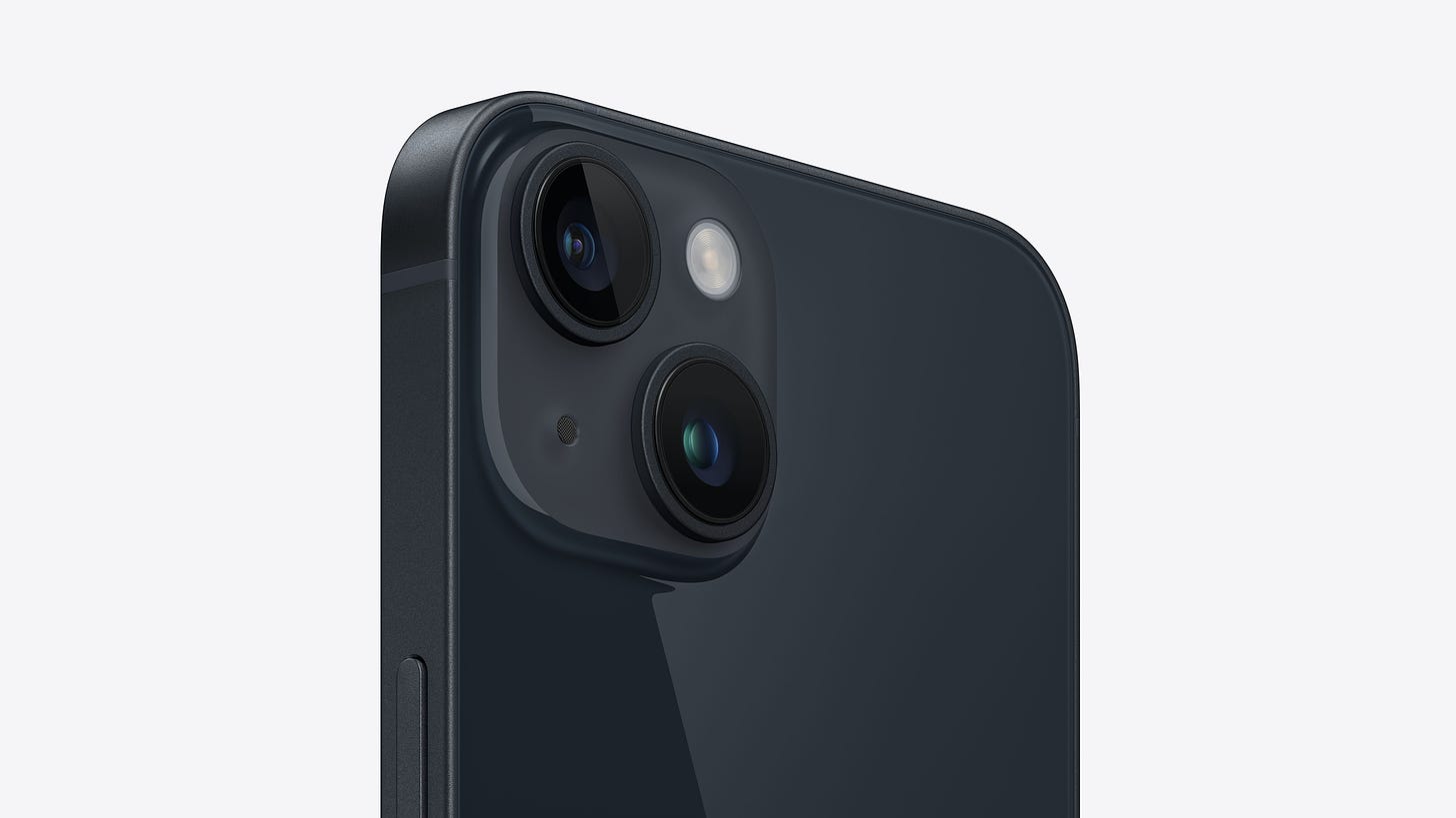 Angled close-up view of the dual-camera system on iPhone 14 in midnight.