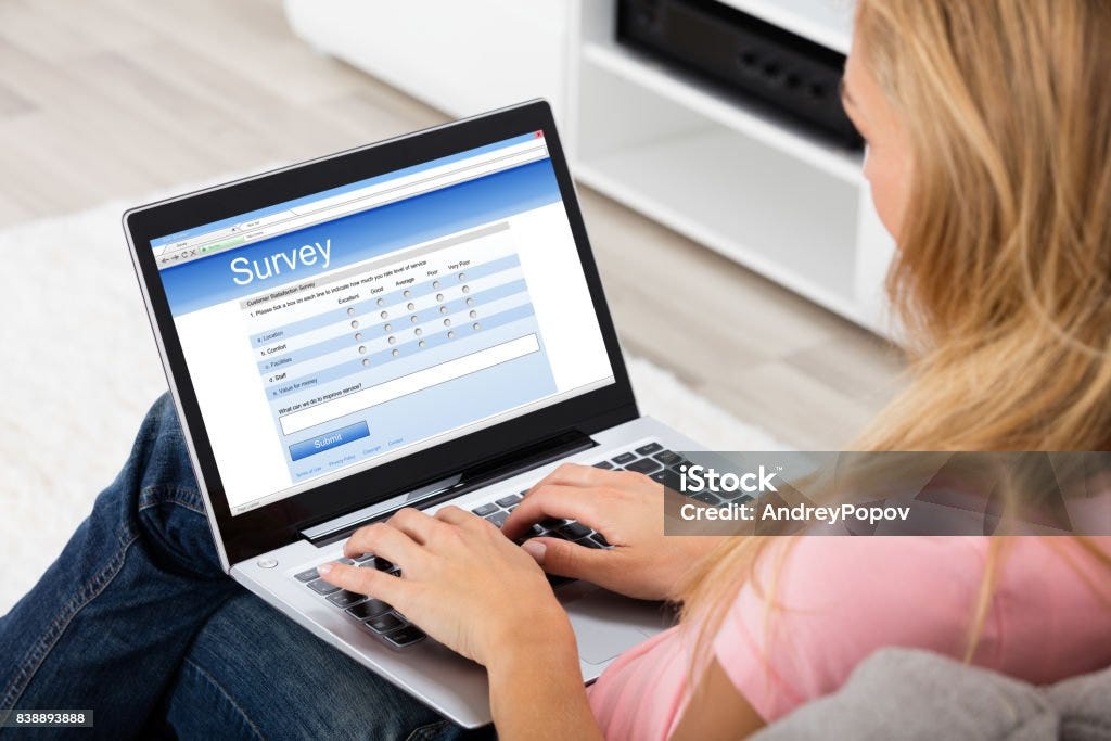Stock photo of woman taking online survey questionnaire on computer