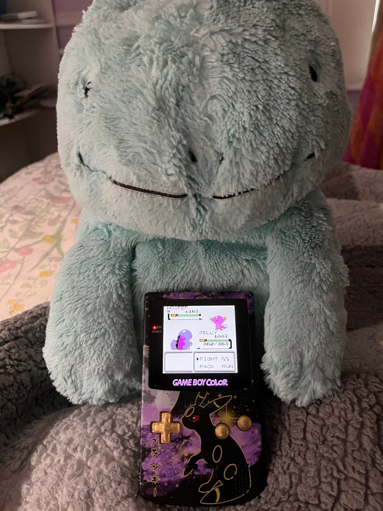 Ayano's favourite Pokémon is Quagsire, and she has a well loved plush of one called Jelly! Also pictured is a custom Game Boy Color with backlight, featuring Umbreon on the shell