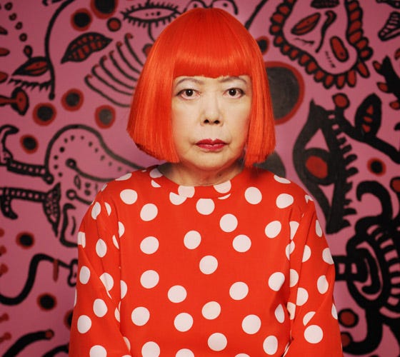 Foto de yayoi Kusama delante de uno de sus originales cuadros lleno d edibujos y formas