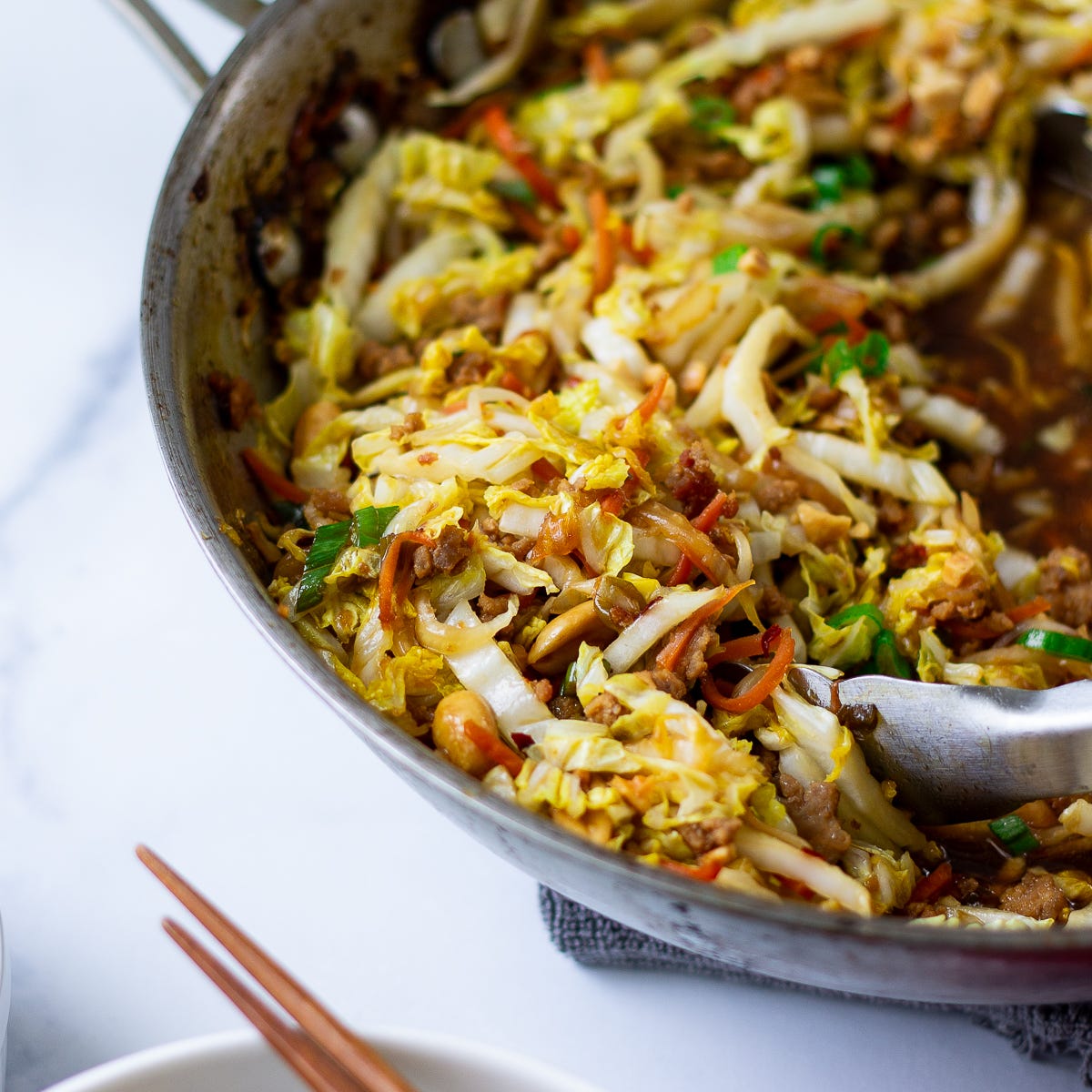 A close up view of cabbage stir-fry in a wok. 