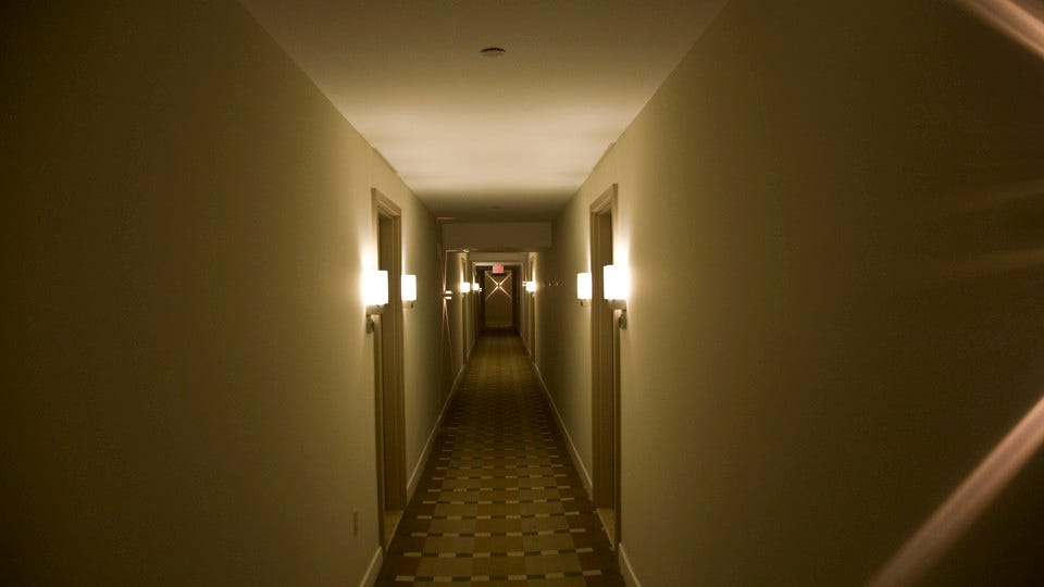 A long, dimly lit hallway with a patterned rug