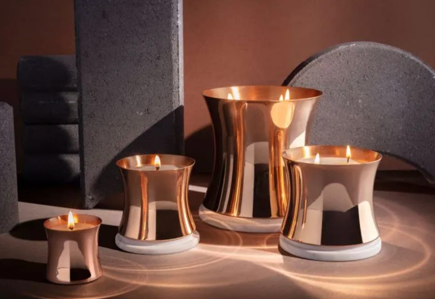 collection of candles in copper vessels of varying sizes and heights