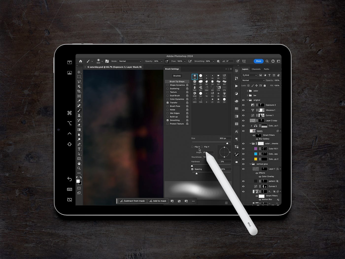Looking down on an iPad with Photoshop occupying the entire screen, and an Apple Pencil hovering above.